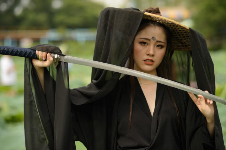 woman,lotus,field,ancient chinese,heroine,hero,asian woman,chinese,china,sword,black dress,nef format,raw,young woman,girl,person,alone,one,a,asia,clothing,cool,style,wear,hand,out door,hold,tattoo on forehead,action,martial arts