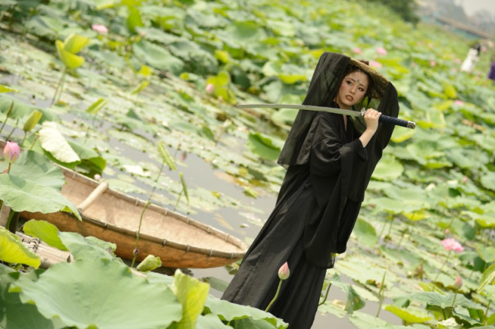 woman,lotus,field,ancient chinese,heroine,hero,asian woman,chinese,china,sword,black dress,nef format,raw,young woman,girl,person,alone,one,a,asia,clothing,cool,style,wear,hand,out door,hold,tattoo on forehead,action,martial arts