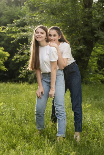 Smiling teenage girl taking selfie with friends while sitting on steps in  city stock photo