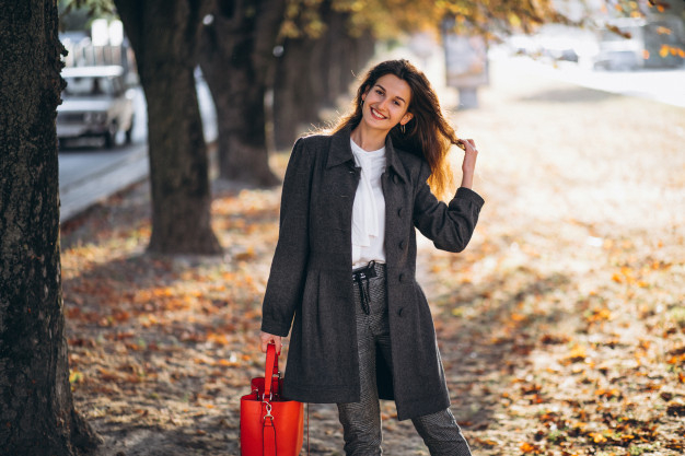 Fashion woman in trendy autumn outfit posing outdoor near see