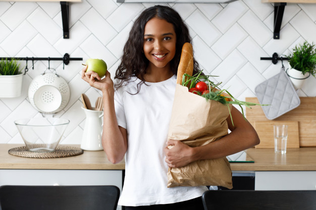 holds,brunette,stands,front,hold,indoor,baguette,goods,groceries,alone,afro,vegetarian,portrait,best,young,female,african,tomato,stand,lady,package,vegetable,healthy,market,organic,bag,apple,smile,shopping,home,kitchen,girl,paper,woman,house,food