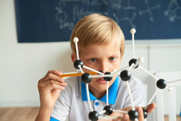 examining,assembling,biochemistry,little,intelligent,curious,counting,molecular,looking,experiment,atom,plastic,structure,research,model,laboratory,chemistry,boy,person,child,kid,science,education,school