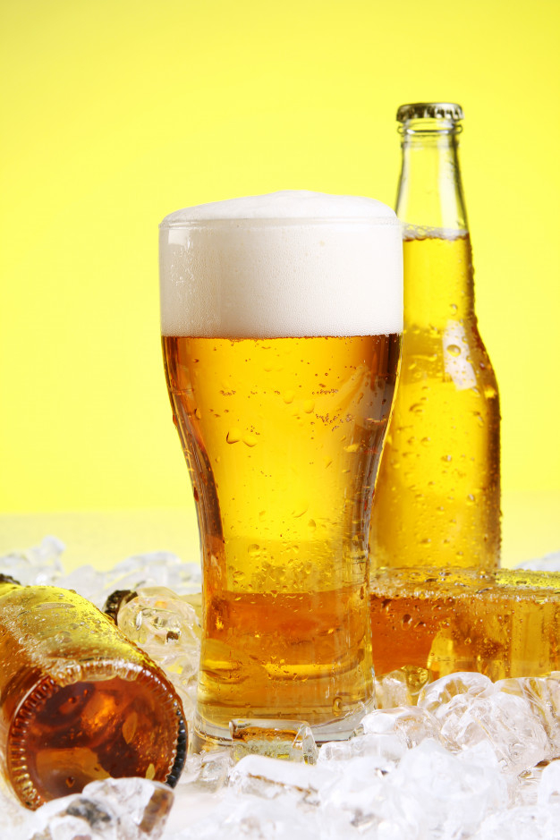 Free Stock Photo of Cold bottles of beer in ice on yellow background