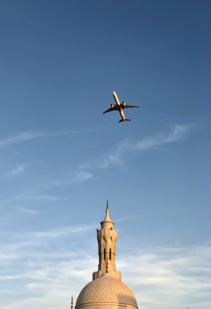 aircraft,aircraft wing,airplane,airplane wing,architecture,aviation,blue sky,clouds,daylight,dome,flight,flying,high,mosque,outdoors,photography,religion,sacred,sky,traditional,transportation,transportation system,travel,trip,trip (journey),wing