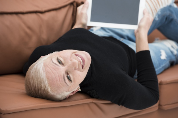 Free Elder Woman Smiling And Relaxing On The Couch With Tablet Free Photo Nohat Cc