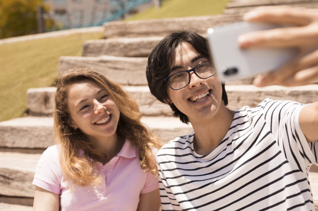 multiethnic,multiracial,taking selfie,casual clothes,taking,affection,cheerful,blonde,casual,handsome,leisure,outdoors,smiling,horizontal,sunny,relationship,bright,device,beautiful,asian,young,together,urban,youth,stairs,friendship,selfie,fun,modern,smartphone,couple,glasses,clothes,happy,cute,mobile,camera,summer,city,love