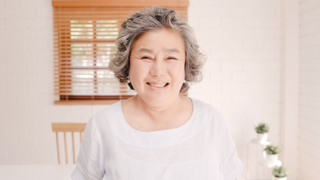Portrait of happy Asian woman in living room, Relaxing mature
