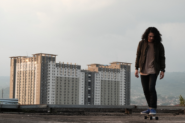 youth,young,wear,urban,skateboarding,skateboarder,skateboard,person,outdoors,modern,man,landscape,hairstyle,fashion,cityscape,city,building,architecture