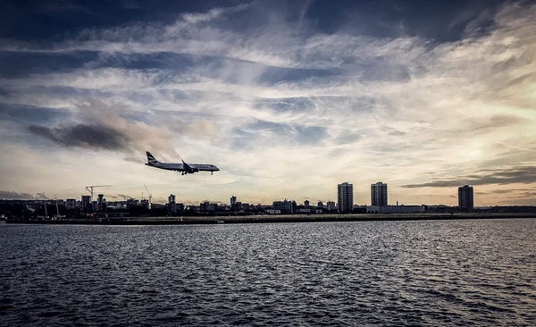 aircraft,airplane,architecture,buildings,city,cityscape,clouds,dawn,dusk,evening,flight,flying,harbor,outdoors,pier,sea,sky,skyline,skyscraper,sunset,transportation system,travel,vehicle,water,waterfront,waves,Free Stock Photo
