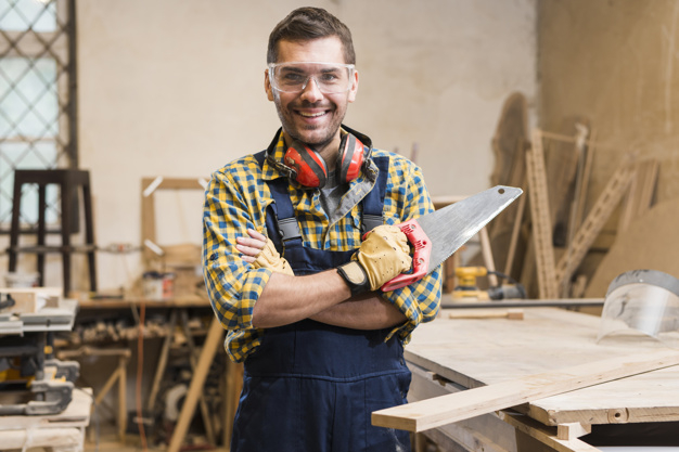 business,people,camera,man,smile,happy,furniture,human,board,person,business people,business man,factory,worker,safety,wooden,young,workshop,professional,tool,happy people,wooden board,block,portrait,arm,panel,carpenter,male,profession,saw,instrument,holding,adult,plank,occupation,smiling,looking,standing,goggles,folded,front,handsome,sharp,eyewear,defender,crossed,workwear,woodworker,protective,handsaw,indoors,earmuffs,handtool,waistup,woodshop