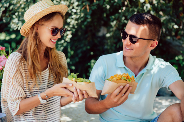 food,summer,dog,man,happy,time,couple,fast food,street,fun,sunglasses,lunch,urban,talking,eating,young,fast,snack,hot dog,beautiful