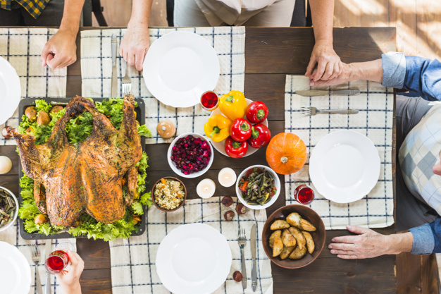 food,people,hand,family,thanksgiving,table,home,chicken,celebration,holiday,human,drink,candle,plate,vegetable,pumpkin,dinner,salad,human body