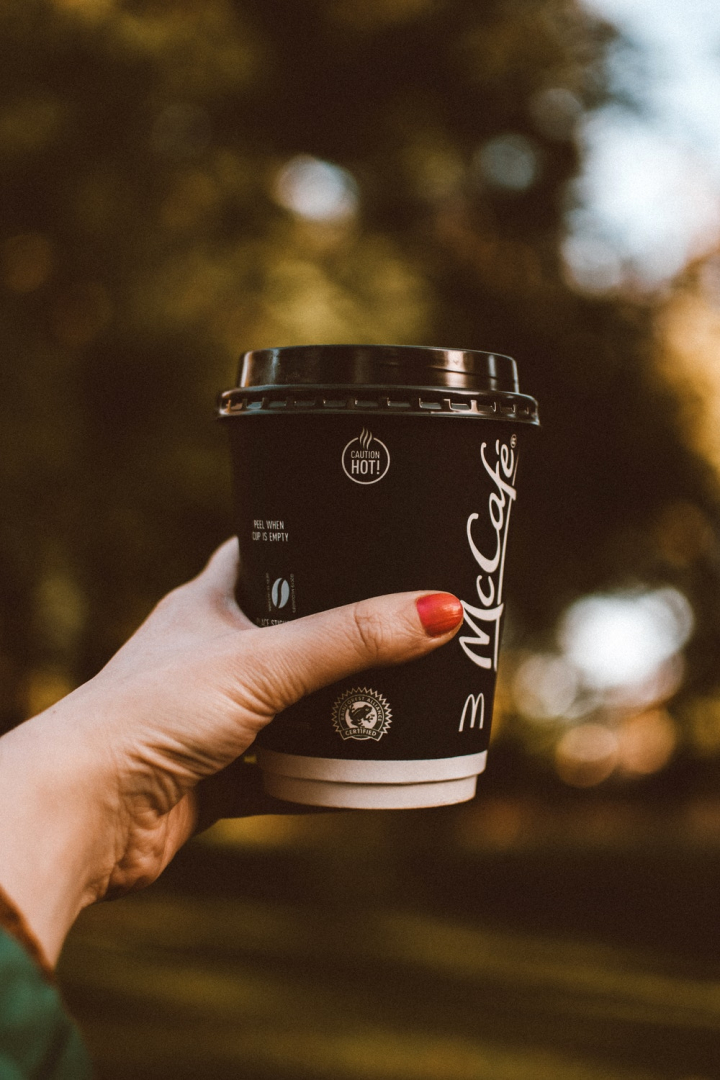 beverage,caffeine,coffee,coffee cup,coffee to go,cup of coffee,hand,holding,hot drink,mccafe,refreshment,selective focus,woman