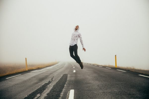 25-30 year old,adult,adventure,clouds,cloudy,highway,jumping,outdoors,trip,view,young,asphalt,blurred background,caucasian,excited,foggy,freedom,hood,leaping,male,man,outdoor,road,shoes,sweatshirt,travel,traveler,vacation