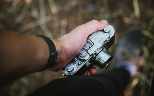 zoom,wristwatch,woods,vintage,person,outdoors,man,lens,human,hand,focus,device,close-up,classic,camera,blur,adult,action