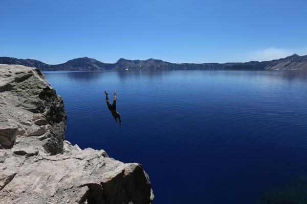 man,diving,lake,water,cold,cliff,blue sky,clear,still,calm,adventure,brave
