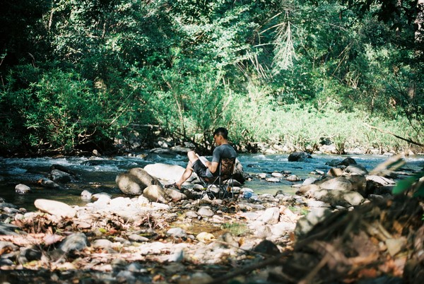 chair,creek,environment,forest,man,outdoors,person,reading,recreation,relax,river,rocks,stones,stream