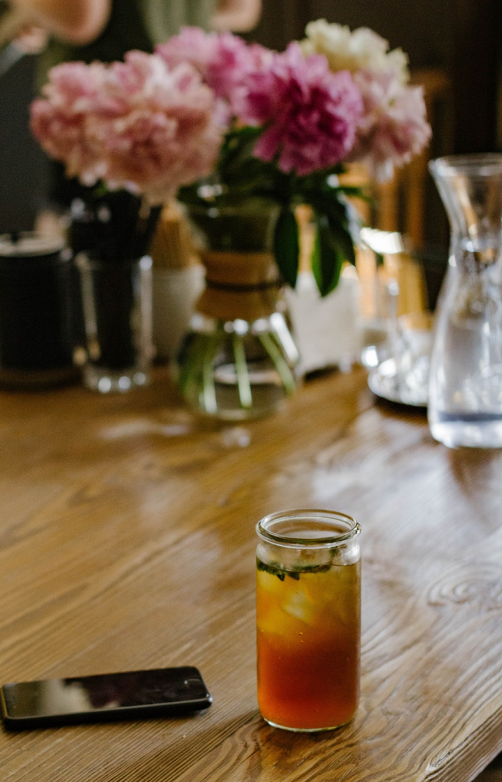 beverage,blurred background,bright,cellphone,close-up,cold,cold drink,colors,delicious,drink,drinking glass,flowers,focus,glass,glass items,healthy,homemade,ice,icee,indoors,juice,liquid,refreshing,refreshment,table,tasty,tea,wood,wooden,wooden table,yummy