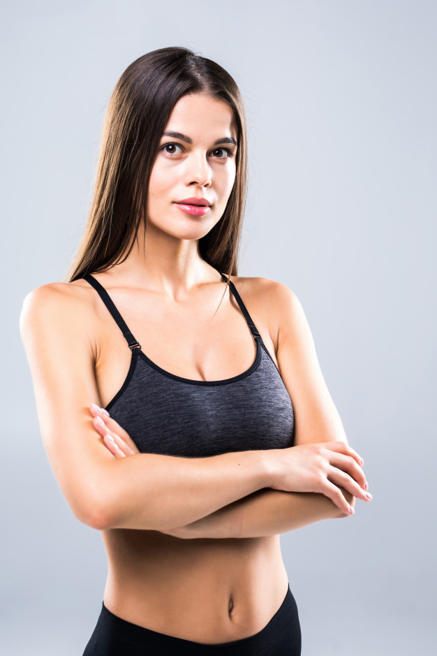 Lifestyle portrait of fitness pretty young woman wearing grey