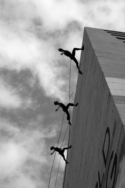 wall,skill,silhouettes,ropes,recreation,performance,people,outdoors,high,height,daytime,danger,dancing,dancers,dance,clouds,building,black and white,ballet dancer,ballet,balance,action,acrobatics