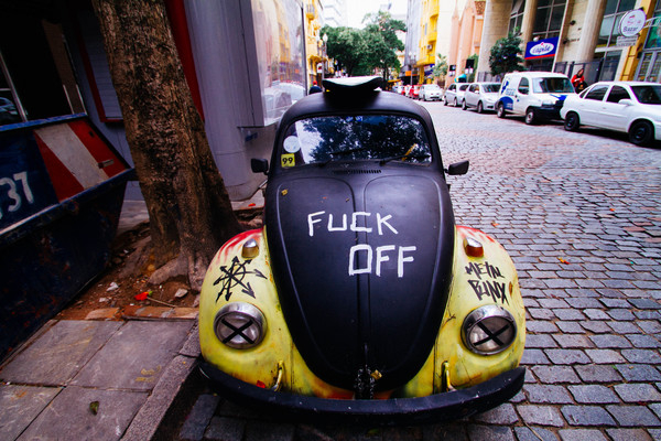 action,automobile,automotive,buildings,business,cars,city,design,drive,graffiti,outdoors,parked,road,stone pavement,street,traffic,transportation system,travel,urban,vehicles,vintage,Volkswagen Beetle,Free Stock Photo