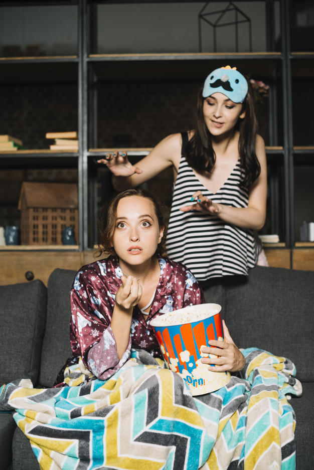 food,people,house,woman,fashion,home,beauty,room,movie,fun,living room,funny,sofa,model,popcorn,friend,television,youth,eating,female,young,fresh,expression,fashion model,beauty woman,bucket,couch,gesture,facial,holding,adult,pretty,stylish,living,standing,two,taste,front,tasty,watching,casual,scare,enjoyment,freshness,fashionable,closeup,indoors,gesturing