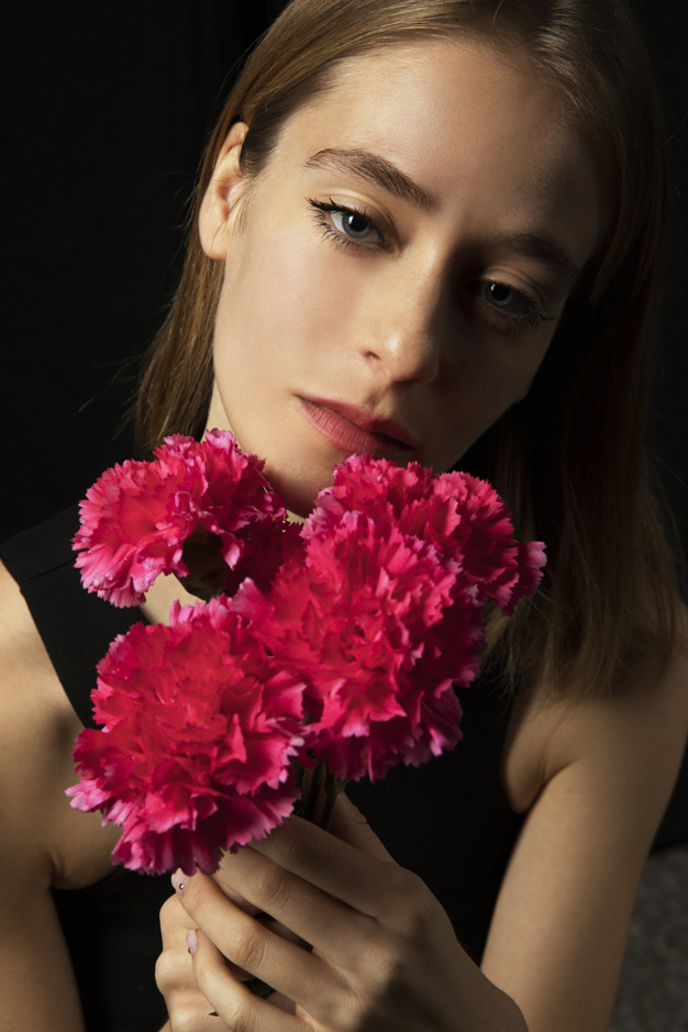 looking at camera,studio shot,pensive,thoughtful,posing,blond,sensual,carnations,bloom,dreaming,carnation,standing,looking,calm,pretty,shot,adult,holding,petal,season,bright,portrait,beautiful,blossom,fresh,young,dark,bouquet,female,romantic,branch,studio,lady,model,natural,plant,person,colorful,black,spring,face,cute,black background,hair,pink,camera,woman,summer,floral,flower,background