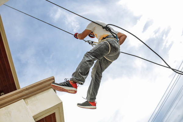 skill,safety,rope,outdoors,man,harness,eyewear,equipment,daytime,danger,clouds,balance,adult
