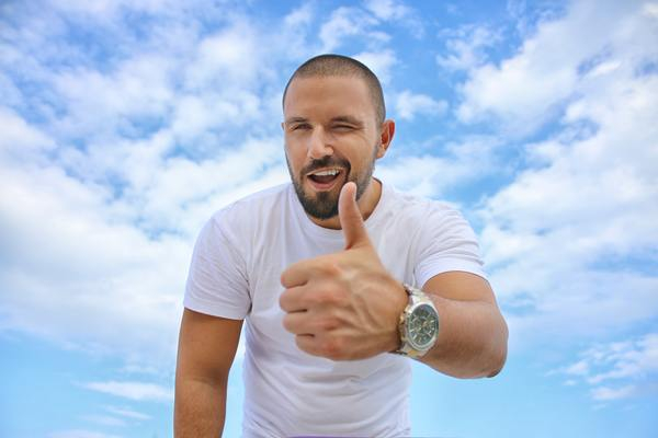man,thumbs up,wink,smile,happy,blue sky,clouds,white,t shirt,watch