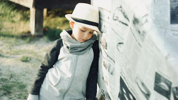 young,child,thinking,pensive,hat,newspaper,beach,sand,thoughful,think