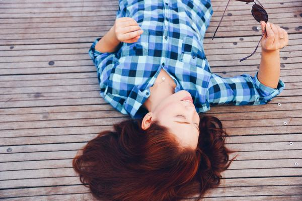 girl,woman,smile,smiling,happy,people,brunette,long hair,plaid,shirt,fashion,clothes,sunglasses,wood,deck,outdoors,lying down