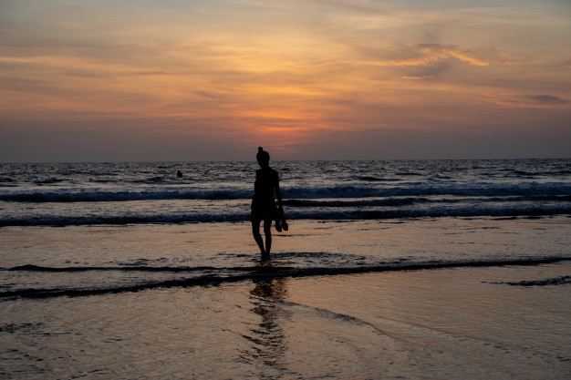 Free: Silhouette of a girl walking on the water on a beach with