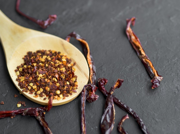 Spices in spoons on black background.