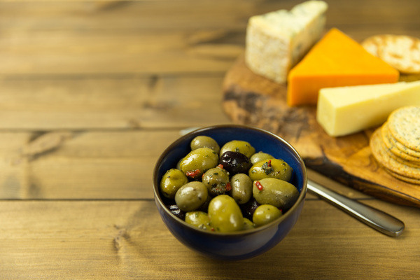 olives,cheese,crackers,table,wood,spoon,bowl,food,snack