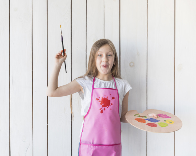 waistup,one,innocence,indoors,innocent,showing,elementary,against,pleasure,long,playful,little,blonde,casual,excited,leisure,childhood,standing,looking,smiling,pallet,plank,holding,hobby,bolt,palette,portrait,apron,happiness,artist,paintbrush,wooden,person,board,white,child,kid,wall,happy,smile,color,art,brush,home,hair,paint,hands,girl,line,education,house,wood,people