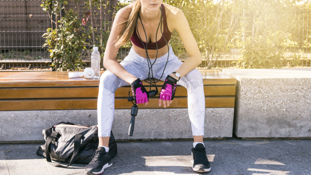 Free: Sportive young woman sitting on bench holding skipping rope in hand 