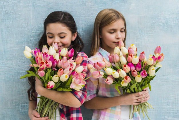 nobody,indoors,abundance,smelling,innocent,freshness,against,bunch,joyful,little,many,cheerful,inside,small,casual,two,childhood,standing,looking,smiling,pretty,tulips,holding,lifestyle,portrait,beautiful,happiness,tulip,female,girls,clothing,sweet,person,backdrop,human,child,kid,wall,happy,smile,cute,beauty,girl,blue,fashion,children,flowers,people,flower,background