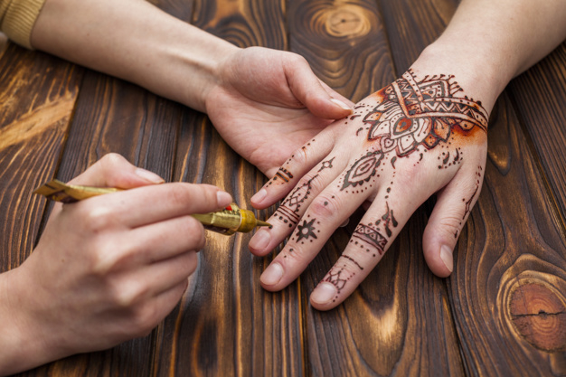 unrecognizable,applying,faceless,body part,making,dye,womans,part,mehndi,crop,anonymous,horizontal,master,holding,ornate,top view,top,beauty woman,hand painted,holding hands,beautiful,view,asian,henna,artist,tool,wooden background,professional,traditional,wood table,culture,skin,brown background,hand drawing,wooden,brown,pattern background,nature background,natural,ethnic,body,drawing,process,desk,decoration,wood background,person,tattoo,art,background pattern,paint,table,woman,ornament,hand,pattern,background