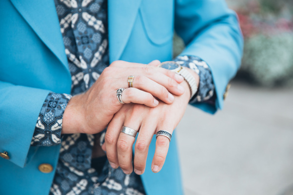 25-30 year old,adult,blue,clothing,gold,hand,jacket,one person,outdoors,portrait,standing,buttoned cuff,caucasian,coat,fashion,fashionable,fingers,glass,lifestyle,male,man,nails,outside,patterned shirt,person,pocket,rings,style,stylish,turquoise blue jacket,wrist watch