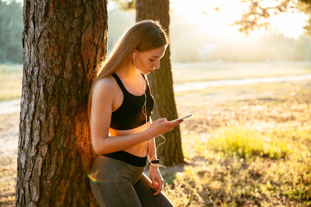 tree,music,summer,nature,sport,fitness,smartphone,person,park,training,headphones,female,cellphone,young,workout,beautiful,lifestyle,top,tank,listen