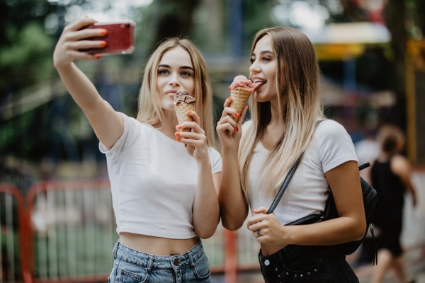 Portrait of Two Young Beautiful Fashionable Girls Posing in Street