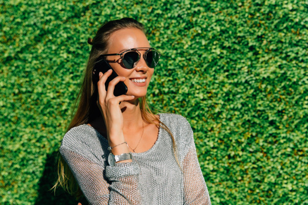technology,summer,green,phone,mobile,happy,internet,telephone,smartphone,modern,mobile phone,sunglasses,walking,female,talking,conversation,cellphone,young,beautiful,lifestyle