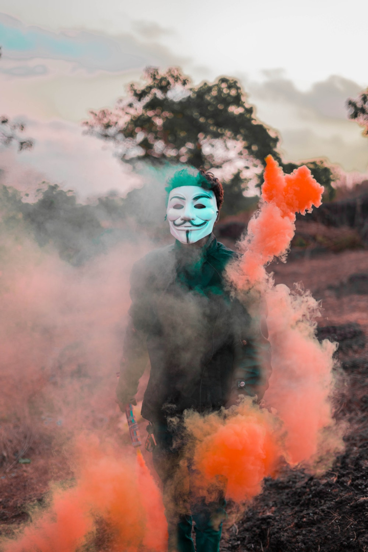 Free: Person Wearing Guy Fawkes Mask Surrounded With Colored Smoke -  