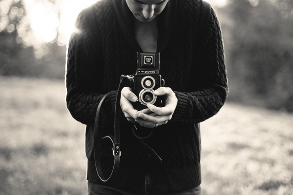 black and white,camera,man,argoflex,lens,picture,strap,sweater,people