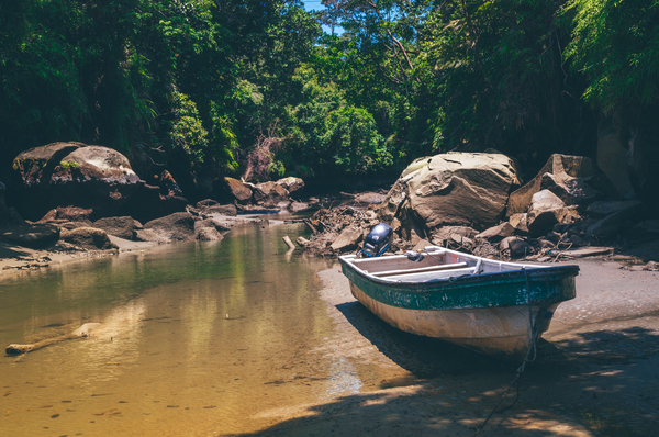 boat,boulders,daylight,environment,forest,landscape,motor boat,nature,outdoors,rocks,scenic,stream,trees,water,watercraft,woods