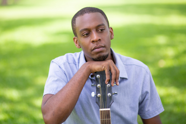 green,man,grass,black,shirt,guitar,person,park,african,young,sitting,musical instrument,musical,american,male,musician,guy,instrument