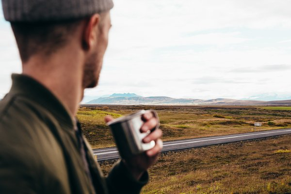  man,cup,road,drink,hills,clouds,nature,icel, scenery