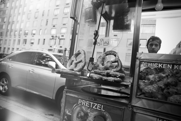food stand,pretzels,chicken,street,display,man,bandana,car