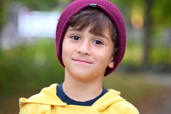  child,young boy,purple hat,yellow top,young child,children api, smiling child