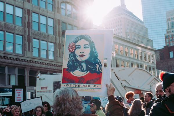 protest,woman,womens march,beautiful,woman,female,person,protest,sign,demonstration,womens march,we the people,placard,holding up,people,group,sunlight,flare